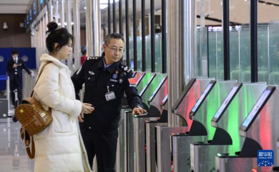 1月2日，大興機(jī)場邊檢站警察指導(dǎo)旅客使用自助出境設(shè)備。新華社記者 李欣 攝