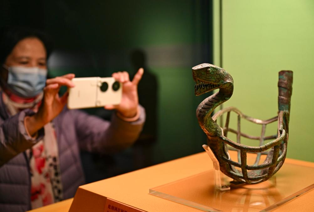 1月14日，觀眾在上海博物館蛇年迎春展拍攝展品蛇綱網(wǎng)狀銅器。新華社發(fā)（陳浩明攝）