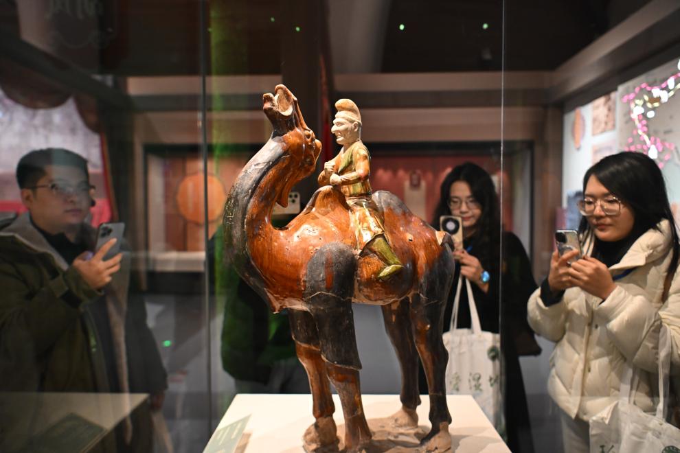 1月15日，觀眾在拍攝“長安三萬里——陜西唐代文物精華展”展出的三彩胡人騎駝俑。（新華社記者 孫凡越 攝）