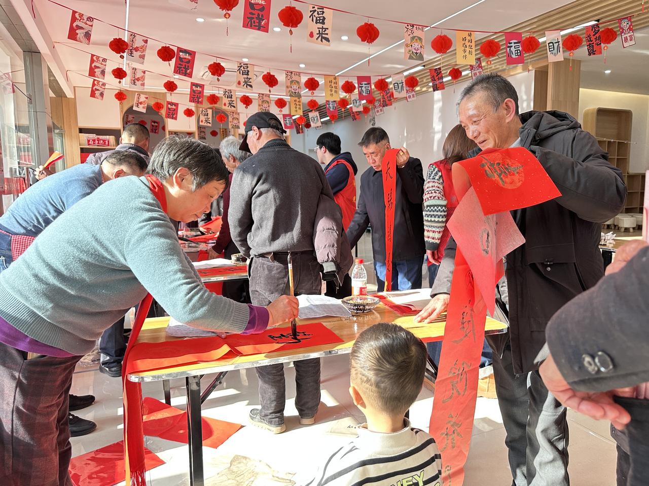 今年春節(jié)前夕，慶元縣濛洲街道同濟(jì)新村，一場送春聯(lián)活動熱鬧舉行。慶元縣融媒體中心 供圖