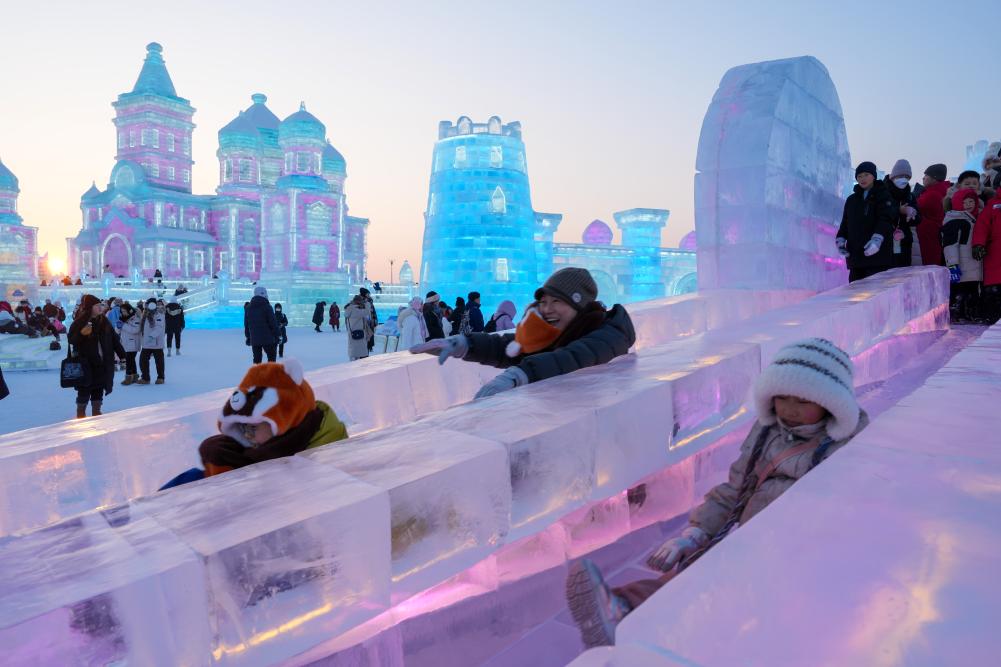 游客在哈爾濱冰雪大世界園區(qū)內(nèi)體驗(yàn)冰滑梯。新華社發(fā)