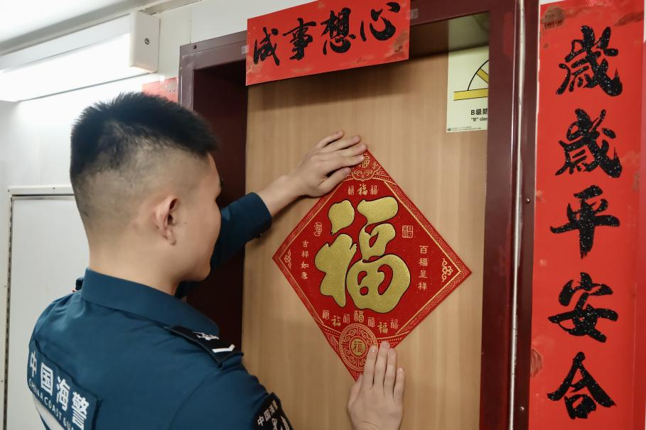 1月27日，在中國(guó)海警海鷗艦上，執(zhí)法員貼春聯(lián)福字慶祝農(nóng)歷春節(jié)。