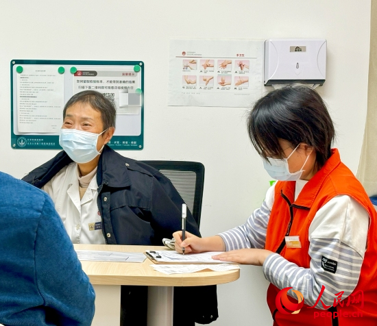 秦苑（中）接診患者。人民網(wǎng)記者 金慧慧攝