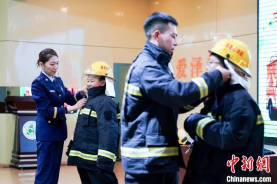 圖為學(xué)生們現(xiàn)場(chǎng)穿戴消防頭盔和戰(zhàn)斗服。中新社記者 趙宇航 攝