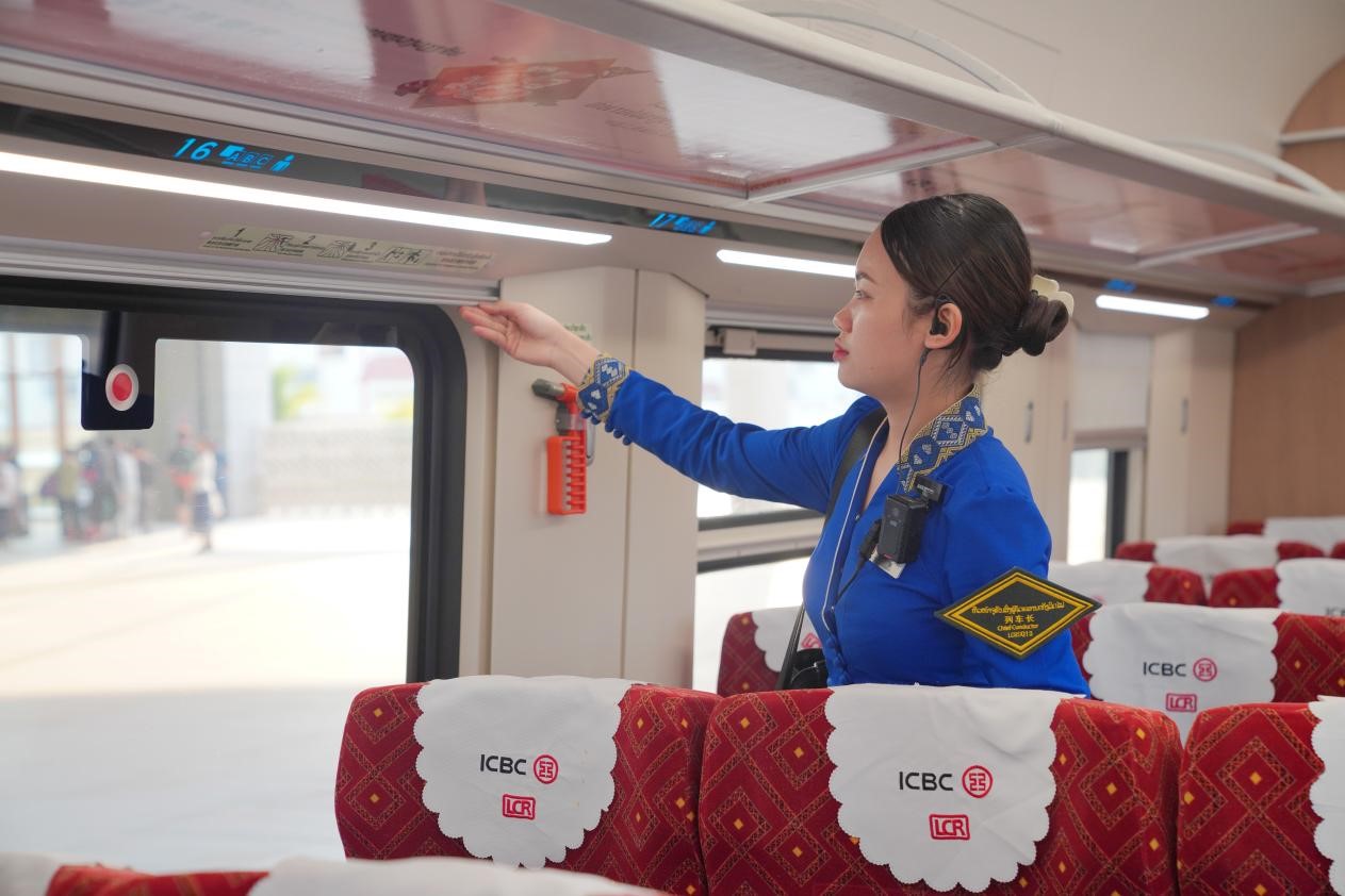 中老鐵路瀾滄號(hào)動(dòng)車組列車長(zhǎng)小麗正在進(jìn)行車廂檢查。老中鐵路有限公司供圖