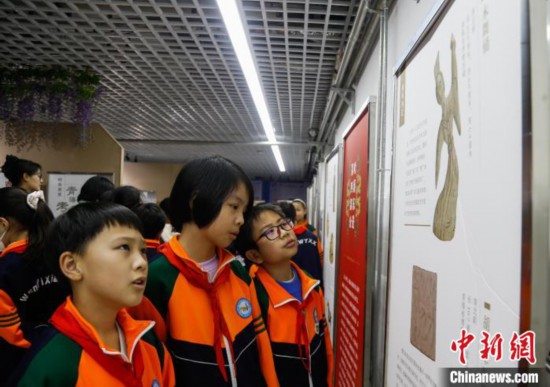 圖為學生參觀青海省博物館“1+3”主題流動展覽，了解木舞俑。中新社記者 馬銘言 攝