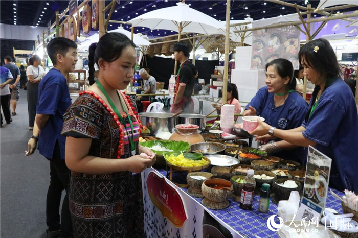 游客在攤位前購(gòu)買(mǎi)特色美食。朱瀟逸攝