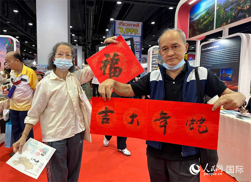2025蛇年春節(jié)，泰國市民展示他們領(lǐng)到的華人手寫春聯(lián)。人民網(wǎng)記者 簡承淵攝