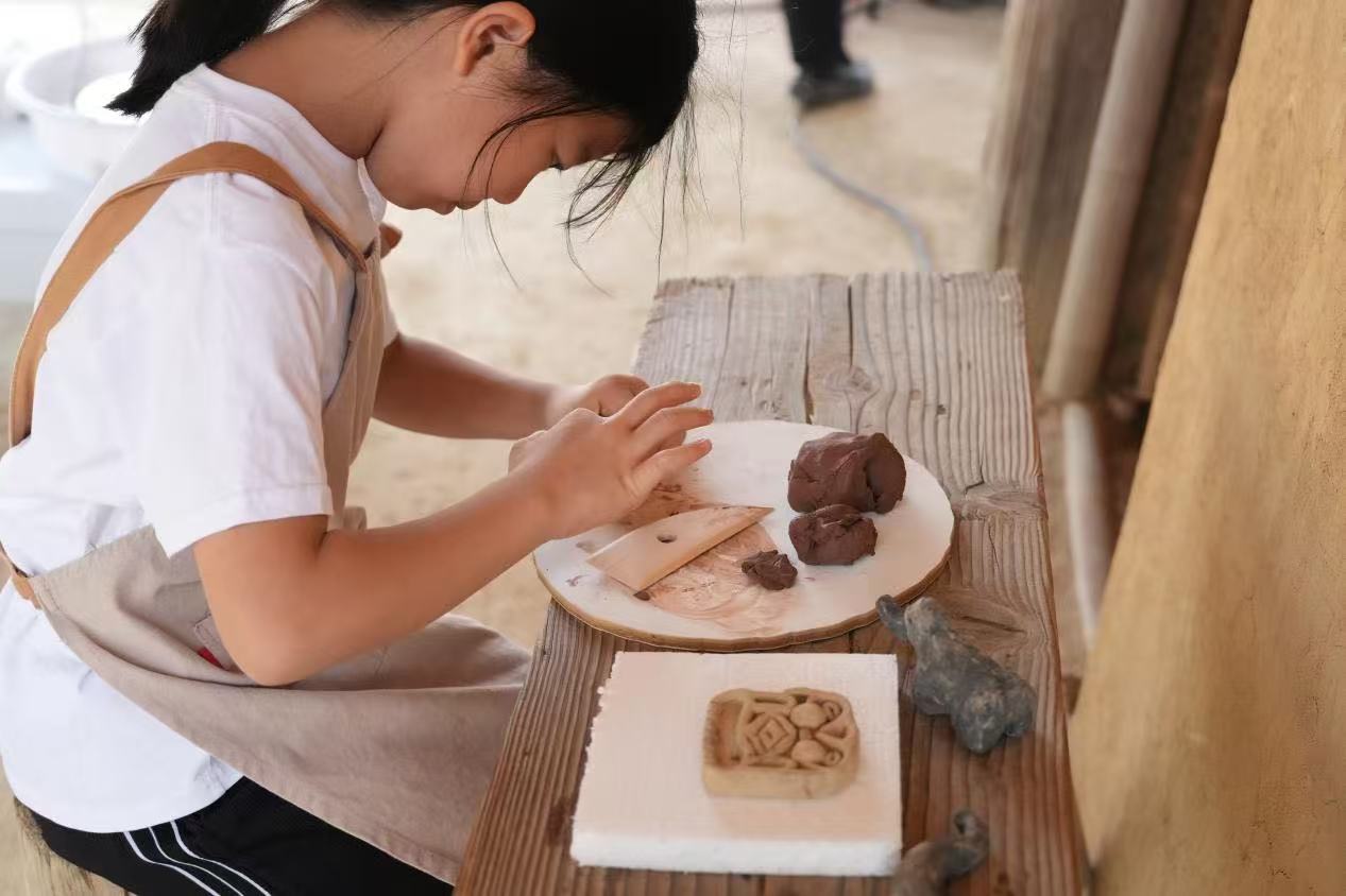 游客制作良渚特色陶藝品。良渚博物院供圖