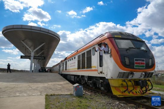 5月31日，在蒙內鐵路內羅畢站，機車駕駛員蔣立平（右）和博爾在即將開往蒙巴薩的E2次列車上揮手致意。新華社記者 楊光 攝
